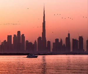 Preview wallpaper city, buildings, water, boat, birds, sunset