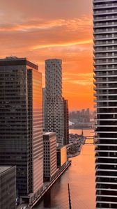 Preview wallpaper city, buildings, water, sunset, aerial view