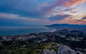 Preview wallpaper city, coast, sea, stones, evening