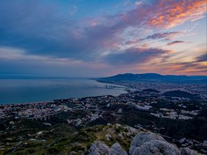 Preview wallpaper city, coast, sea, stones, evening