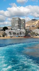 Preview wallpaper city, country, spain, andalusia, roquetas de mar, mountains, buildings, water, sea, waves, sky, clouds