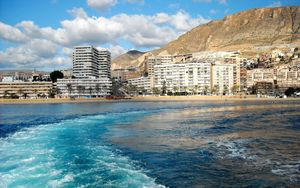 Preview wallpaper city, country, spain, andalusia, roquetas de mar, mountains, buildings, water, sea, waves, sky, clouds