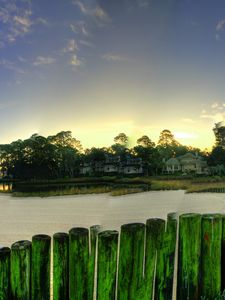 Preview wallpaper city, grass, trees, palm trees, buildings, fences, sand