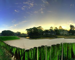 Preview wallpaper city, grass, trees, palm trees, buildings, fences, sand