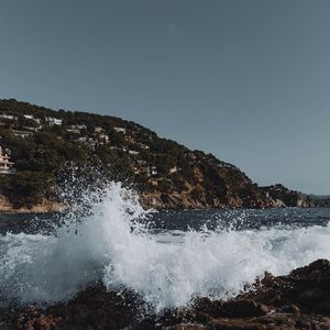 Preview wallpaper city, hill, sea, spray, rocks