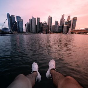 Preview wallpaper city, lake, legs, buildings, coast