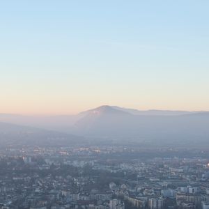 Preview wallpaper city, mountain, fog, sky, aerial view