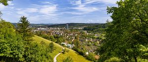 Preview wallpaper city, panorama, hills, trees, forest, sky, clouds