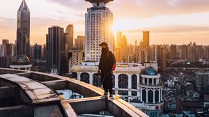 Preview wallpaper city, roof, loneliness, man, solitude, sunset, architecture
