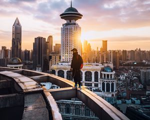 Preview wallpaper city, roof, loneliness, man, solitude, sunset, architecture