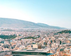 Preview wallpaper city, roofs, mountains, trees