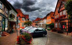 Preview wallpaper city, sky, clouds, cars, houses, flowers, plants