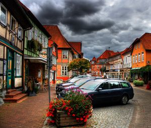 Preview wallpaper city, sky, clouds, cars, houses, flowers, plants