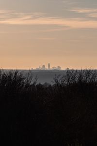 Preview wallpaper city, skyline, sunset, grass, fog