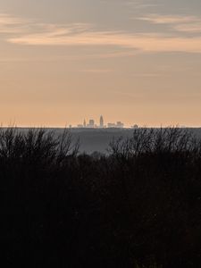 Preview wallpaper city, skyline, sunset, grass, fog