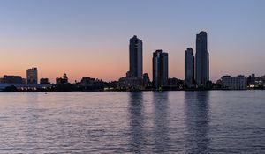 Preview wallpaper city, skyscrapers, buildings, water, evening