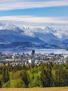 Preview wallpaper city, trees, mountains, snow, snowy, sky