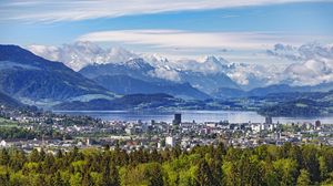 Preview wallpaper city, trees, mountains, snow, snowy, sky