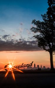 Preview wallpaper cleveland, night city, sunset, silhouettes, inscription, sunlight