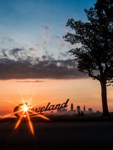 Preview wallpaper cleveland, night city, sunset, silhouettes, inscription, sunlight