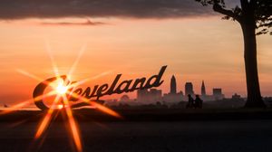Preview wallpaper cleveland, night city, sunset, silhouettes, inscription, sunlight