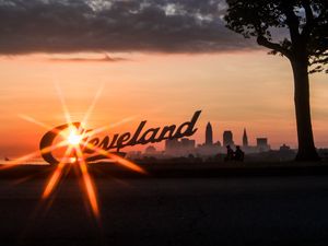 Preview wallpaper cleveland, night city, sunset, silhouettes, inscription, sunlight