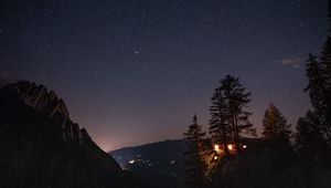 Preview wallpaper cliff, house, night, mountains, starry sky, light