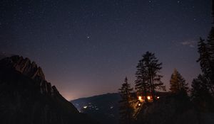 Preview wallpaper cliff, house, night, mountains, starry sky, light