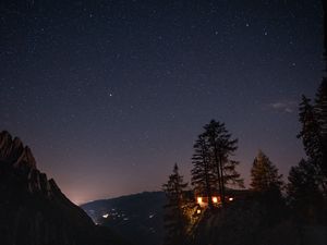 Preview wallpaper cliff, house, night, mountains, starry sky, light