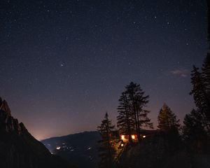 Preview wallpaper cliff, house, night, mountains, starry sky, light
