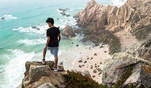 Preview wallpaper cliff, man, rocks, sea, beach, overview