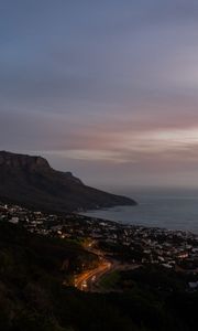 Preview wallpaper cliff, road, buildings, coast, dusk