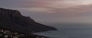 Preview wallpaper cliff, road, buildings, coast, dusk