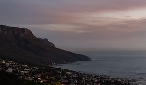 Preview wallpaper cliff, road, buildings, coast, dusk