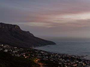 Preview wallpaper cliff, road, buildings, coast, dusk