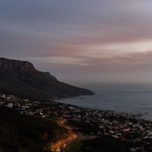 Preview wallpaper cliff, road, buildings, coast, dusk