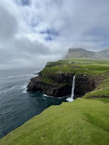 Preview wallpaper cliff, waterfall, sea, grass, fog