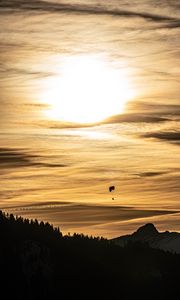 Preview wallpaper clouds, sky, trees, mountains, paraglider, silhouettes, twilight