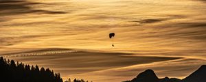 Preview wallpaper clouds, sky, trees, mountains, paraglider, silhouettes, twilight