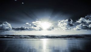 Preview wallpaper coast, beach, sun, clouds, beams, sand, black-and-white