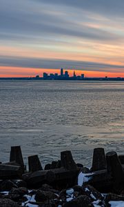 Preview wallpaper coast, city, water, ice, sunset