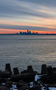 Preview wallpaper coast, city, water, ice, sunset