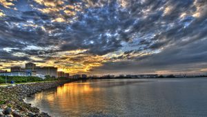 Preview wallpaper coast, clouds, city, morning, road, structures