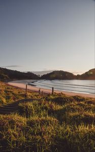 Preview wallpaper coast, hills, sea, stairs, grass, sky