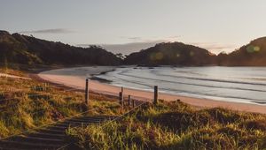 Preview wallpaper coast, hills, sea, stairs, grass, sky