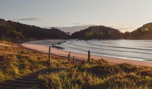 Preview wallpaper coast, hills, sea, stairs, grass, sky