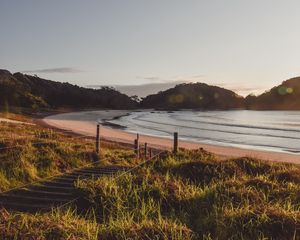 Preview wallpaper coast, hills, sea, stairs, grass, sky