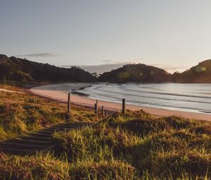 Preview wallpaper coast, hills, sea, stairs, grass, sky