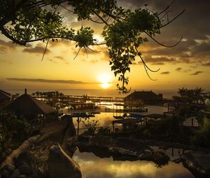 Preview wallpaper coast, houses, sun, sunset, trees, landscape