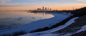 Preview wallpaper coast, lake, winter, snow, city, sunrise